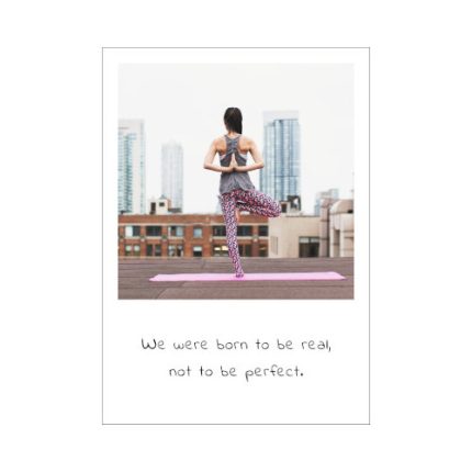 Auf dem Bild der Postkarte Real sehen wir eine Frau die auf einem Dach eine Yoga Übung macht, inmitten des Großstadtdschungels. Der Spruch dazu heißt: We were born to be real, not to be perfect.